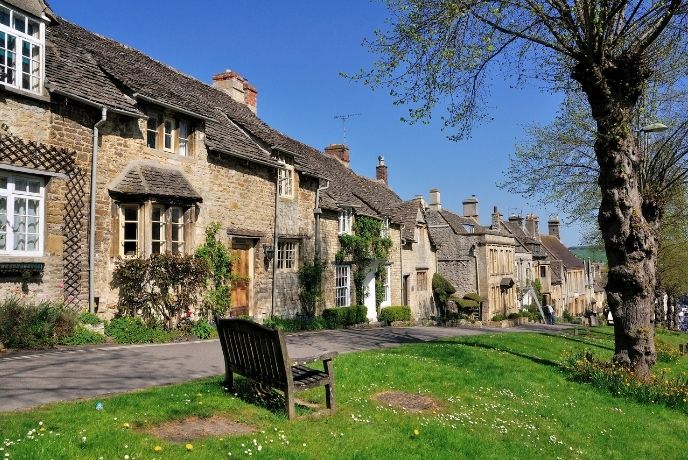 A row of old houses with a bench out front in Burford