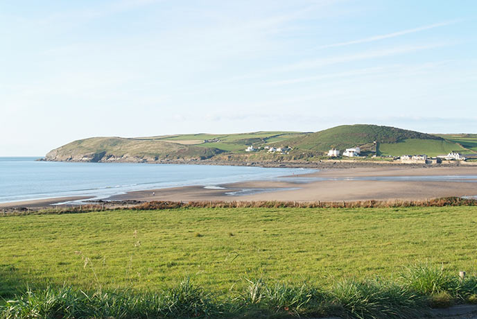 Looking over a field at Croyde Beach on the South West Coast Path