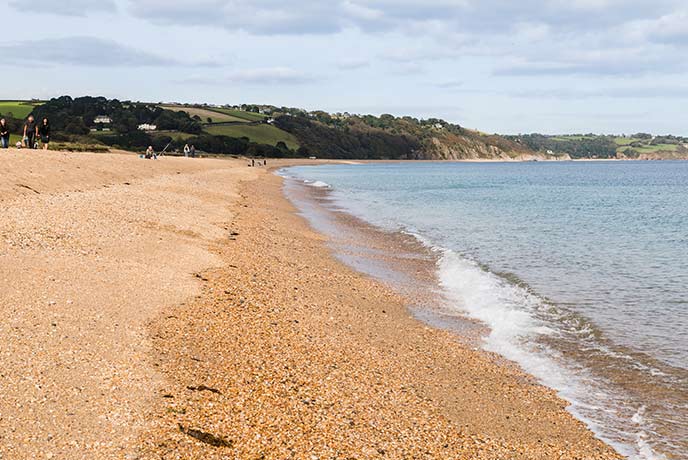 Golden shingles and cliffs in the background of Slapton Sands Beach on the South West Coast Path