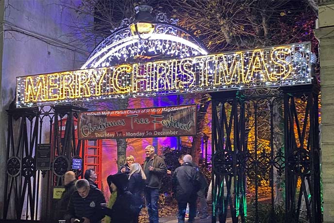 The entrance to the Christmas tree festival at the South Molton Winter Wonderland with a huge Merry Christmas sign lit above