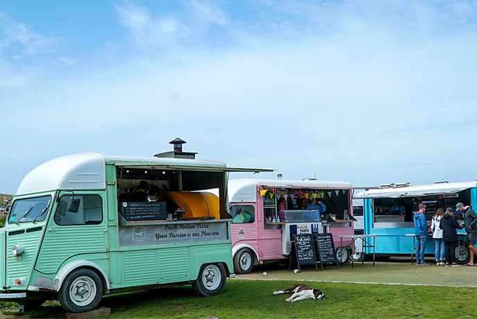 Three pastel coloured food buses ready and waiting to serve up some great food