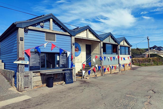 The colourful beach hut style exterior of Britannia at the Beach, one of the best fish and chips in Devon