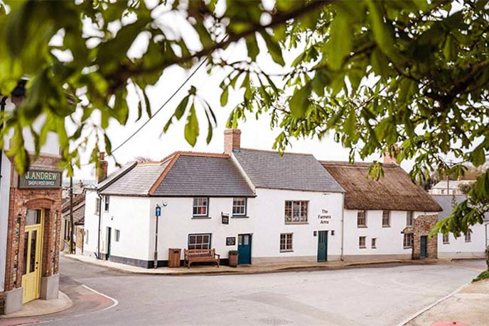 The white-washed exterior of Michelin recommended pub The Farmers Arms in Devon