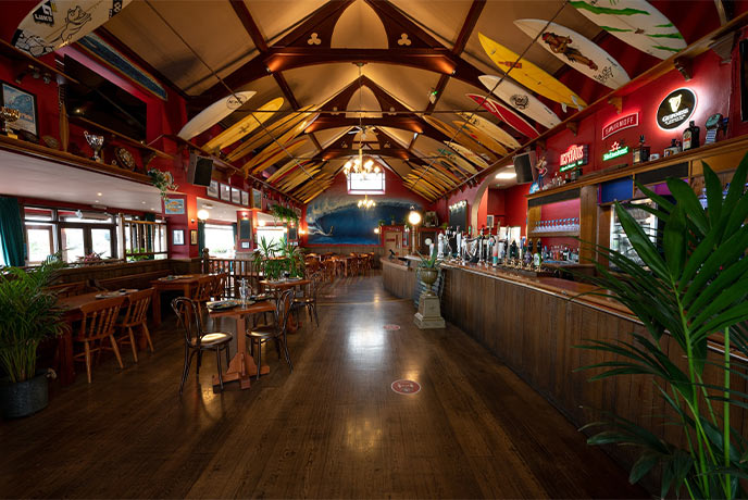 The striking interior of The Red Barn, complete with surfboards on the ceilings