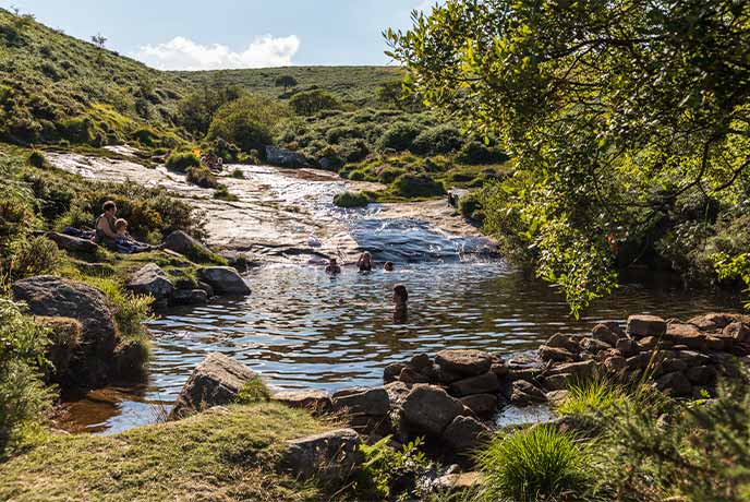 People swimming in the idyllic Shilley Pool in Dartmoor National Park
