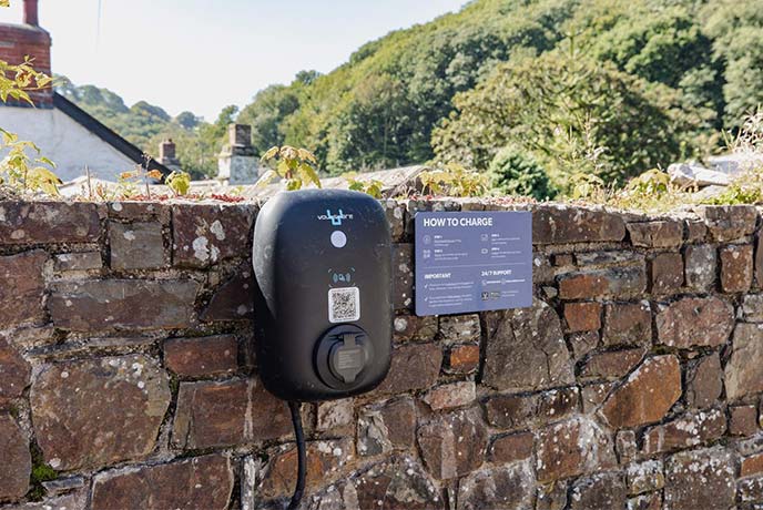 An EV charging point on a stone wall at Bracken Lea in Devon