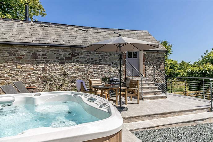 The hot tub sat outside the beautiful stone cottage at Great Eckworthy - The Granary
