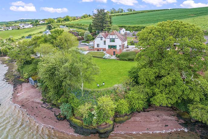 A bird's eye view of Meadowcliff, surrounded by green fields and overlooking the beach and estuary in Devon