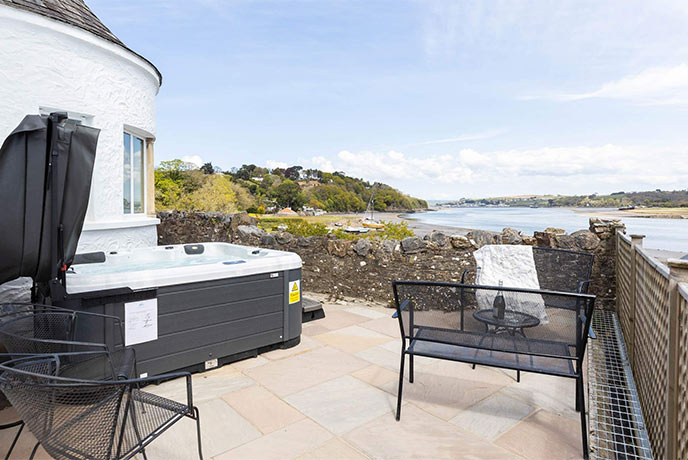 The beautiful terrace at The Old Kiln looking out over the estuary with a hot tub and BBQ