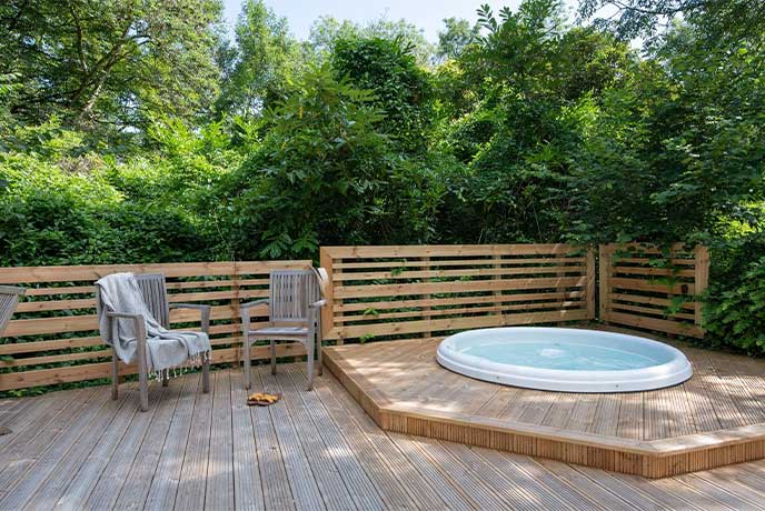 A pretty hot tub embedded in the terrace at Western Torrs Cottage in Devon