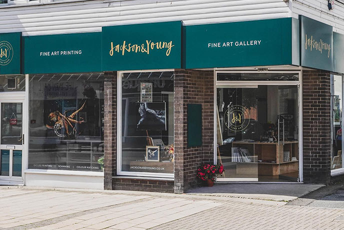 The modern exterior of Jackson & Young Fine Art Gallery, with various pieces of work on display in the windows