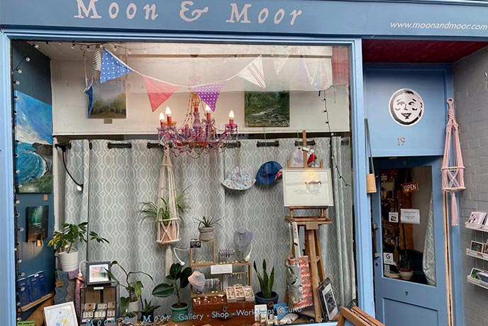 The quirky exterior of Moon & Moor, with a selection of paintings and jewellery in the window