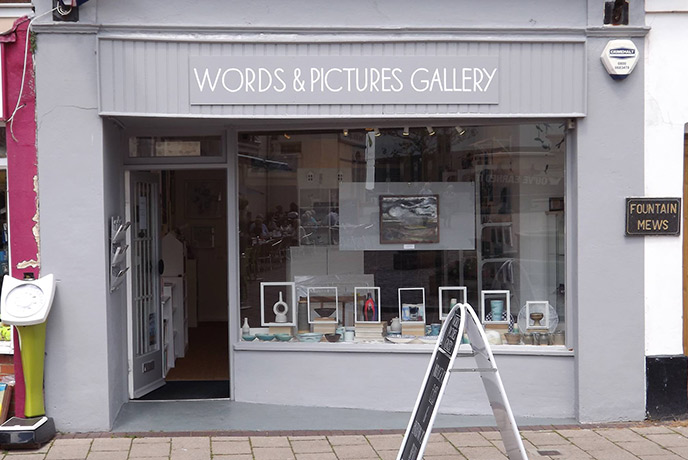 The lilac exterior of Words & Pictures Gallery, with a window full of modern art