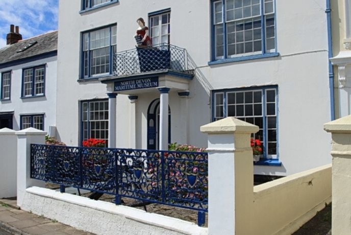 The outside of North Devon Maritime Building with a figurehead over the door
