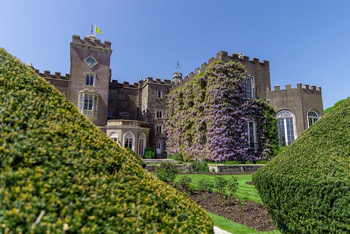 Powderham Castle surrounded by the pristine hedges, where you'll find the Anna Fitzgerald Art Gallery, one of the best art galleries in Devon