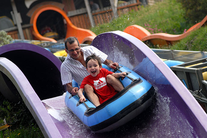 A man and child going down one of the water slides at Woodlands Family Theme park
