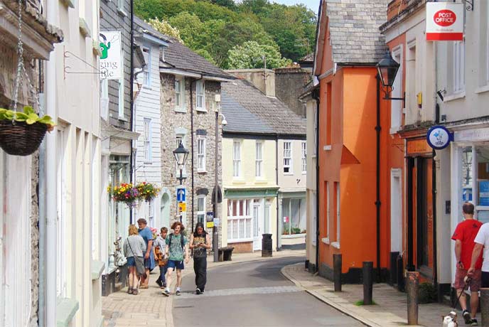People walking up one of the colourful streets in Buckfastleigh in Dartmoor National Park
