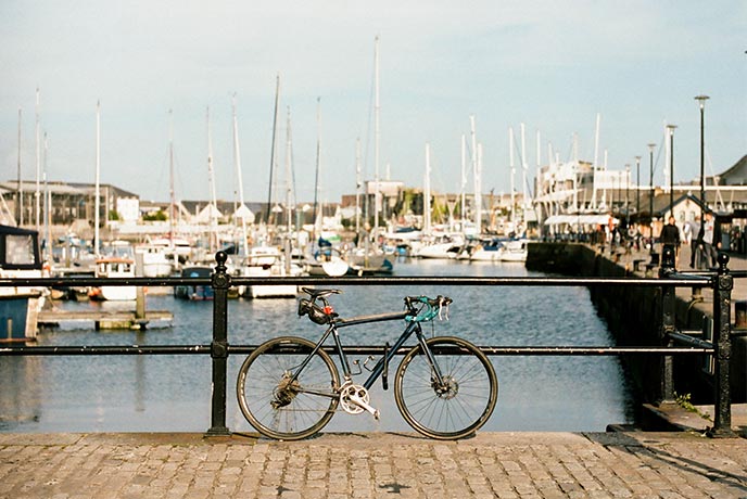 A bike resting against the railing of Plymouth Harbour
