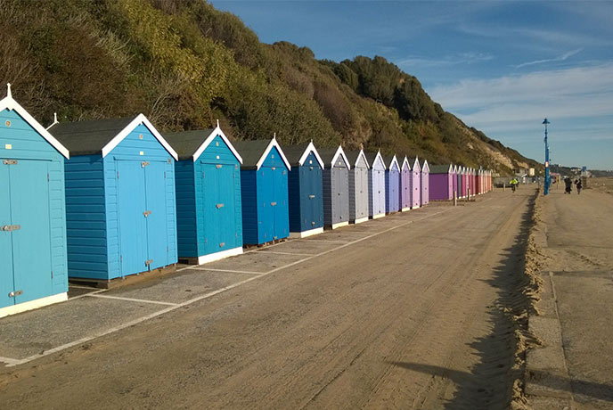 Colourful beach huts line the seafront in Bournemouth, one of the best bike rides in Dorset