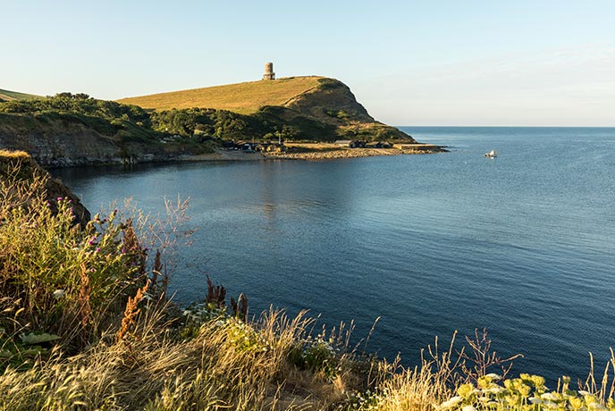 Tide in at dog-friendly Kimmeridge Bay in Dorset with the luscious cliffs behind