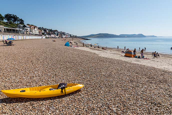 The pebbly beach at Lyme Regis with a kayak on the sand