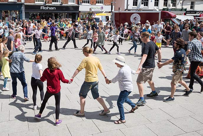 People dancing in a circle at the Wimborne Minster Folk Festival