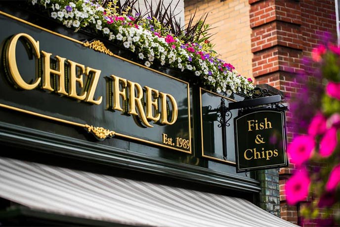 The traditional pub signage of Chez Fred, one of the best places for a fish and chips in Dorset