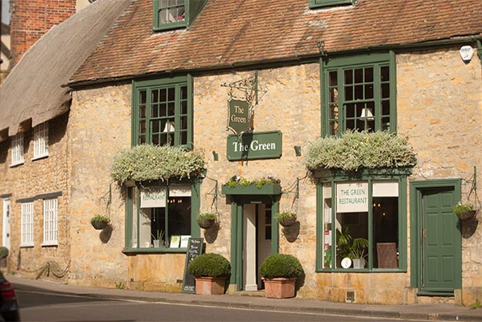 The golden stone exterior of Michelin recommended The Green in Dorset