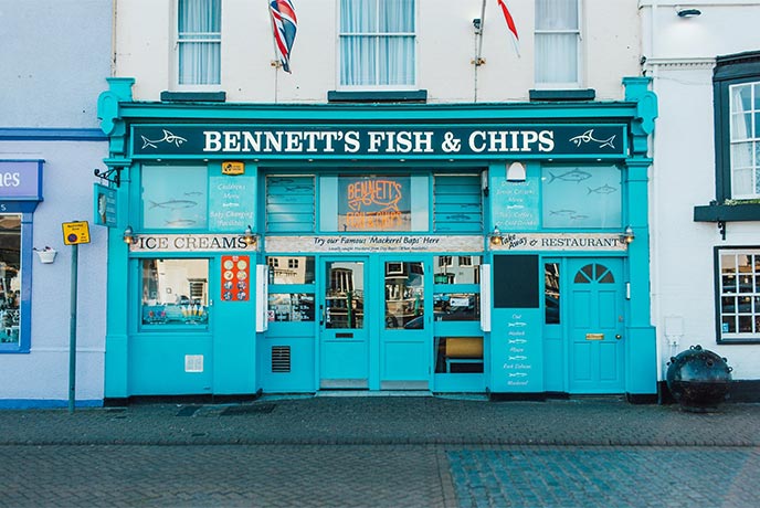 The bright blue shop front of Bennet's Fish and Chips in Dorset