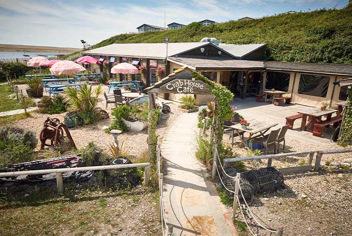 A bird's eye view of the Crab House Café with the sea in the background