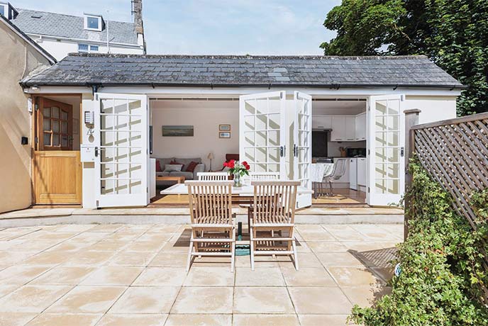 Outdoor tables and chairs in the courtyard of Woodville Cottage in Lyme Regis