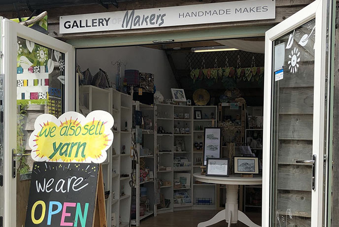 Looking in through the double open doors at the collection of local artwork at Gallery of Makers at Redlands Yards in Dorset