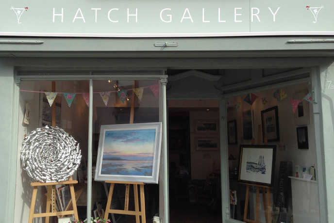 The pretty green shop front of Hatch Gallery, where beautiful paintings and sculptures sit in the window.