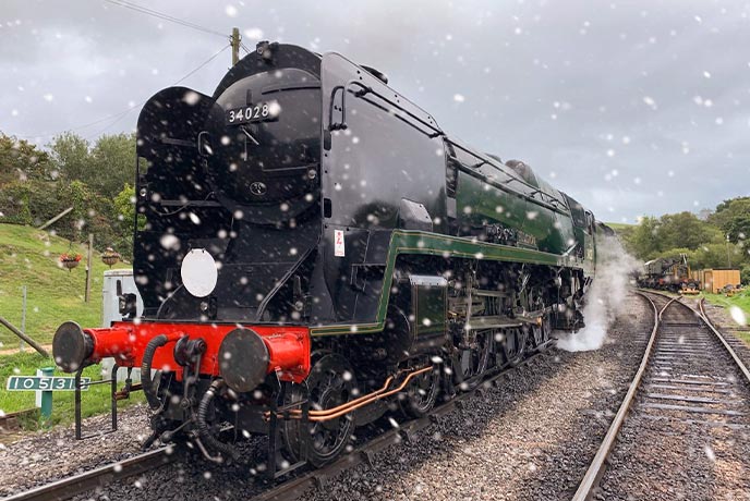A steam train in the snow at Swanage Railway in Dorset