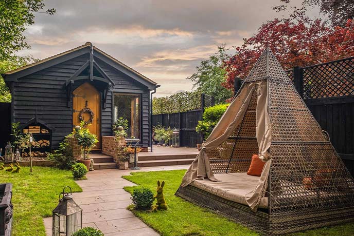 The quaint wooden cabin and outdoor seating tepee at Hideaway Heath Hollow in Essex 