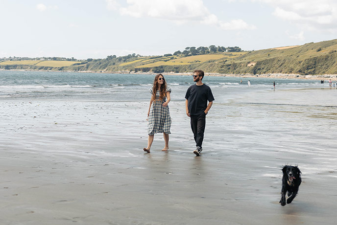 Couple and dog walking on the beach