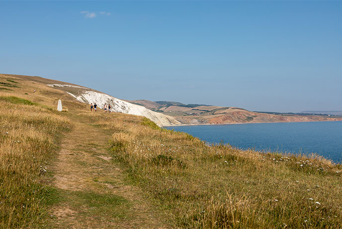 People walking along the coastal path above Freshwater Bay on the Isle of Wight