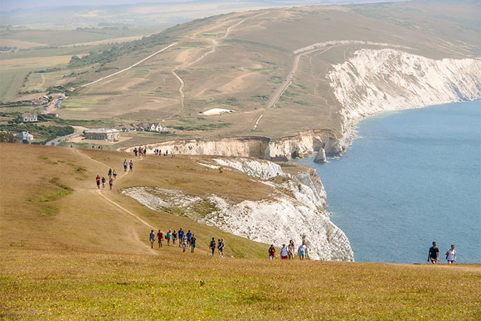 People walking along the coastal path from Freshwater Bay towards the Tennyson Memorial