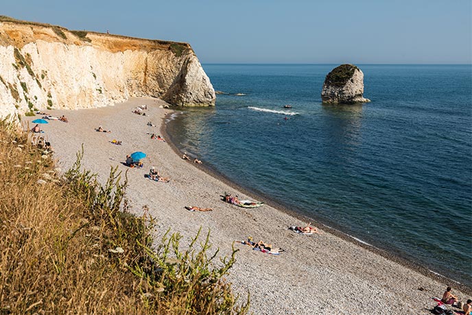 The shingle beach, white cliffs, and stone stacks at Freshwater Bay on the Isle of Wight