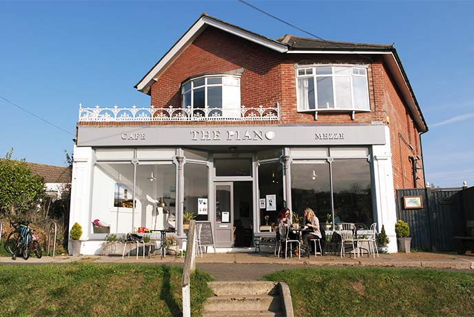 A traditional red-bricked house with a modern café beneath in Freshwater on the Isle of Wight