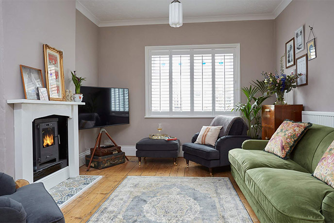 A cosy living room with a green sofa and a fireplace at Leeway House on the Isle of Wight