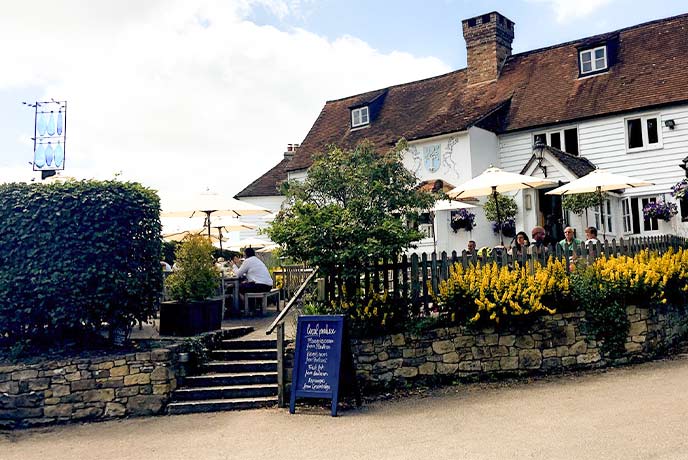 The pretty white exterior of The Bottle House Inn and beer garden in Kent