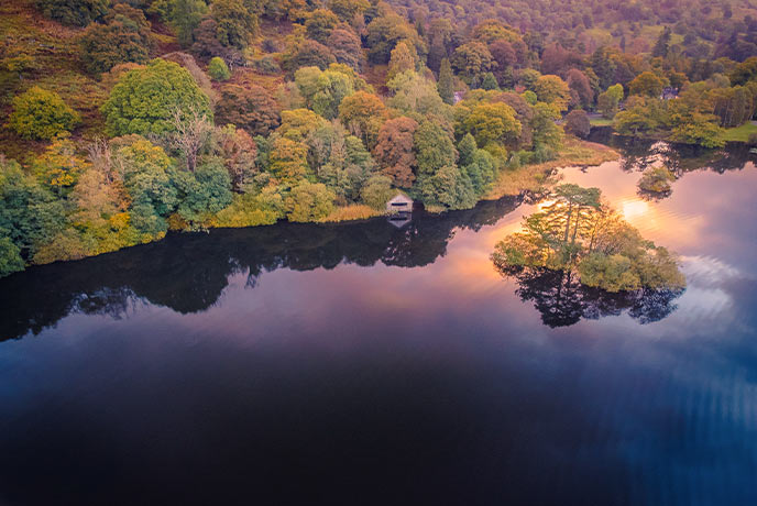 A bird's eye view of Rydal Water near Grasmere with autumnal trees running alongside the water