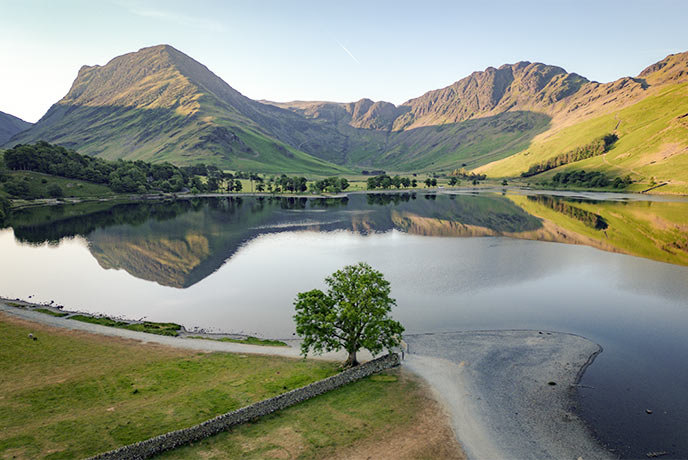 Looking out over the glassy waters of Buttermere Lake with the fells in the background