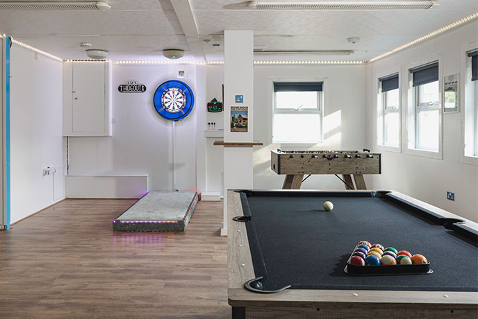 A sleek games room with a pool table and state-of-the-art dartboard