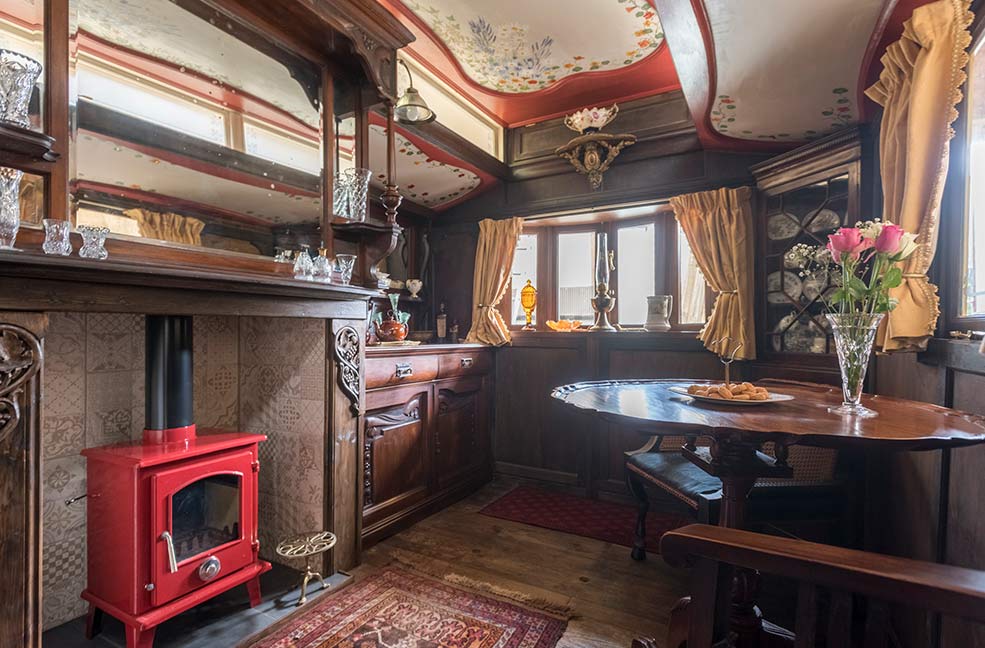 The living area in Sanger's Showman's Wagon in Cornwall has been hand decorated and wood panelled by the owners.