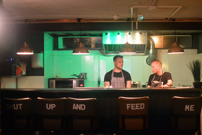 The slogan 'shut up and feed me' is emblazoned across the chairs where you can sit to watch the Nomad chefs cook your food.