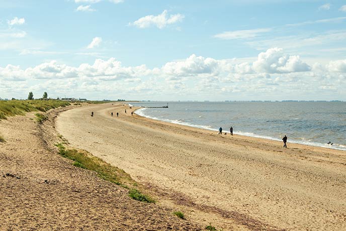 People walking along the golden sands of Heacham North Beach in Norfolk