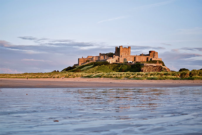 Looking across the water at the dramatic exterior of Bamburgh Castle in Northumberland