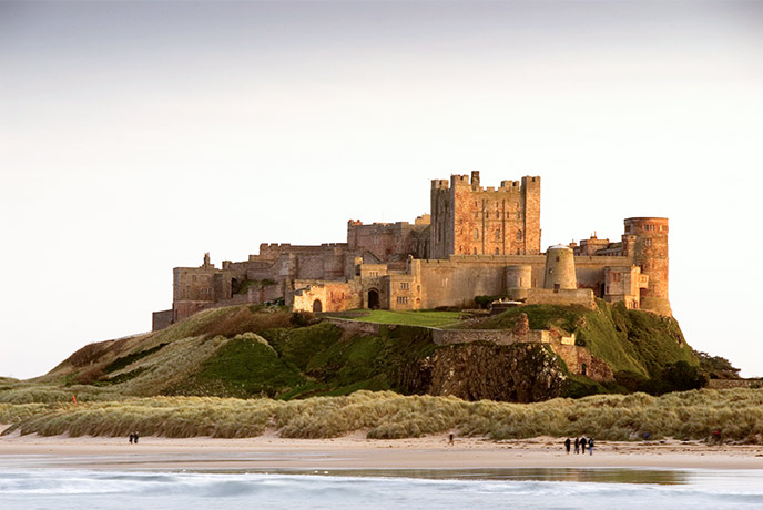 The iconic Bamburgh Castle sitting above the beach in Northumberland